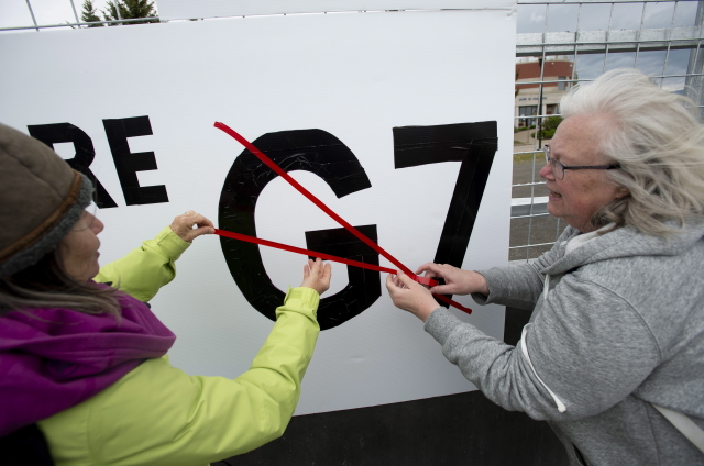 Lidé protestují proti summitu G7.