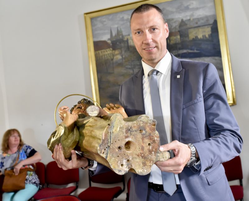 Na snímku radní Petr Wolf ukazuje otvor v soše svatého Tomáše, ve kterém objevili restaurátoři tajný vzkaz s dopisem pro budoucí generace. 