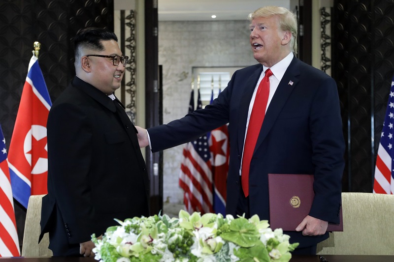Kim Čong-un a Donald Trump odcházejí od stolu.