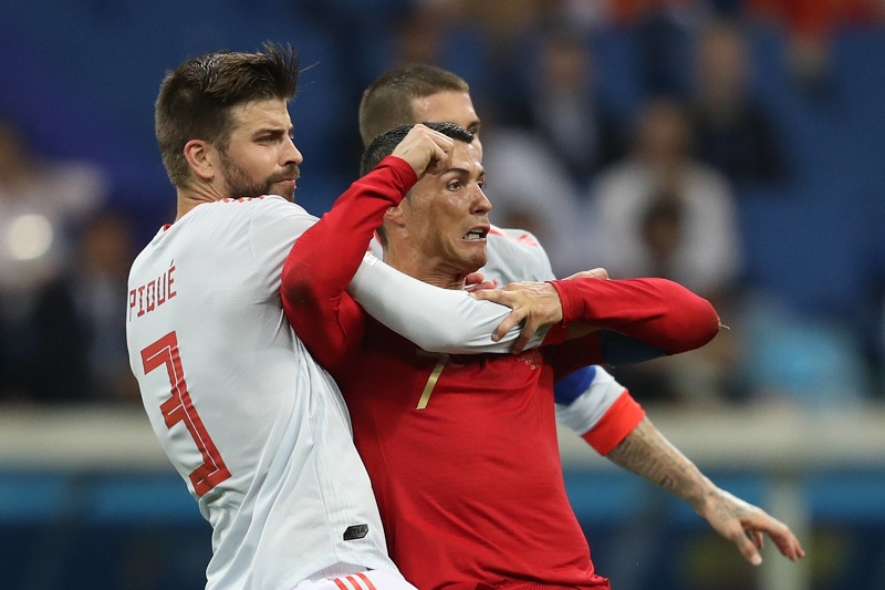 Gerard Piqué (vlevo) v souboji s Christianem Ronaldem.