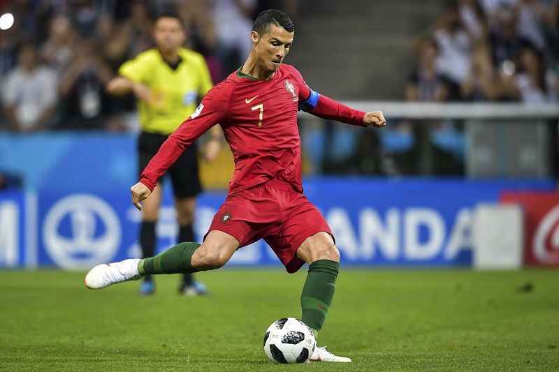 Christiano Ronaldo právě posílá míč přes zeď přesně do sítě. Christiano Ronaldo právě posílá míč přes zeď přesně do sítě.