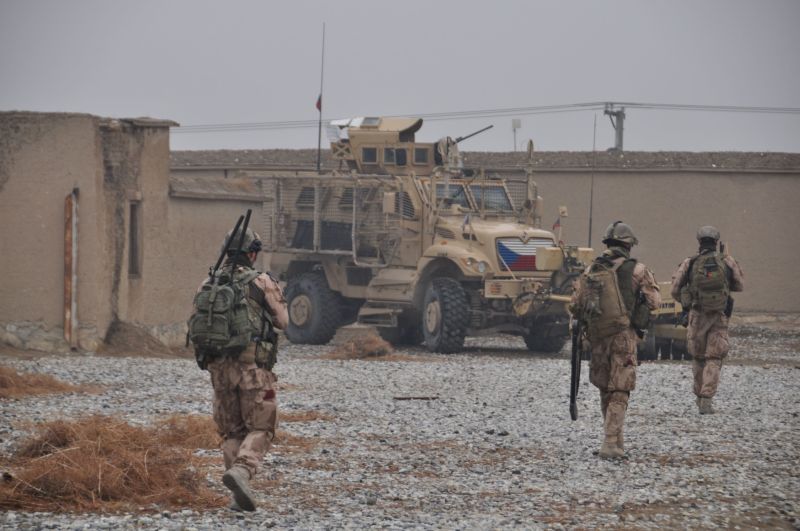 Čeští vojáci na základně Bagrám v Afghánistánu, v pozadí je bojové vozidlo MRAP.