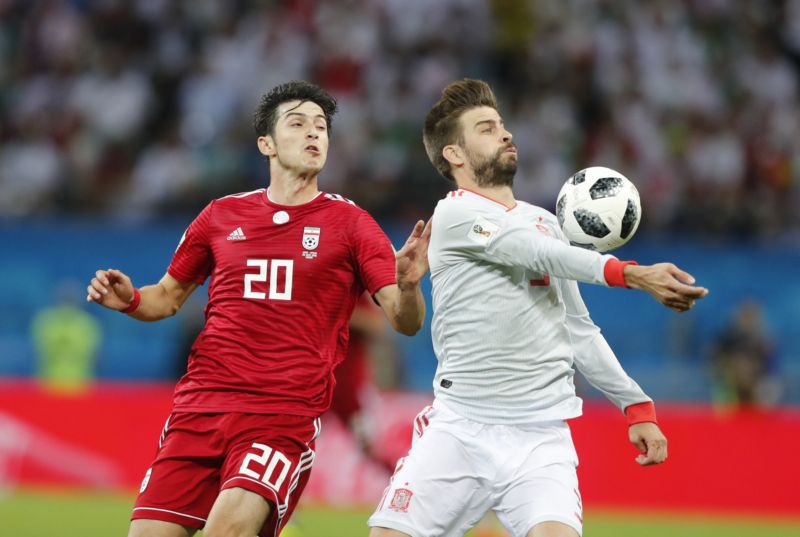 Sardár Azmún (vlevo) v souboji s Gerardem Piquém.