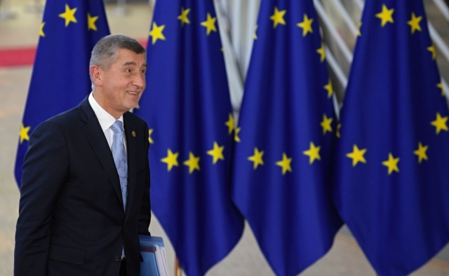 Premiér Andrej Babiš, na pozadí vlajky EU. 
