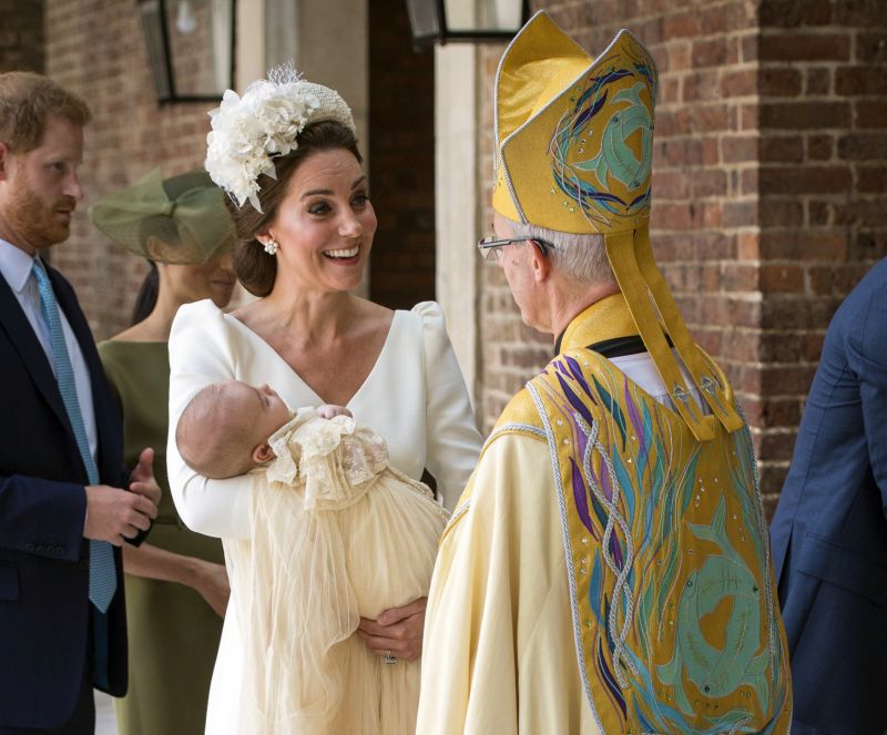 Vévodkyně Kate s princem Louisem mluvící s arcibiskupem Justinem Welbym, v pozadí stojí princ Harry se svou manželkou Meghan.