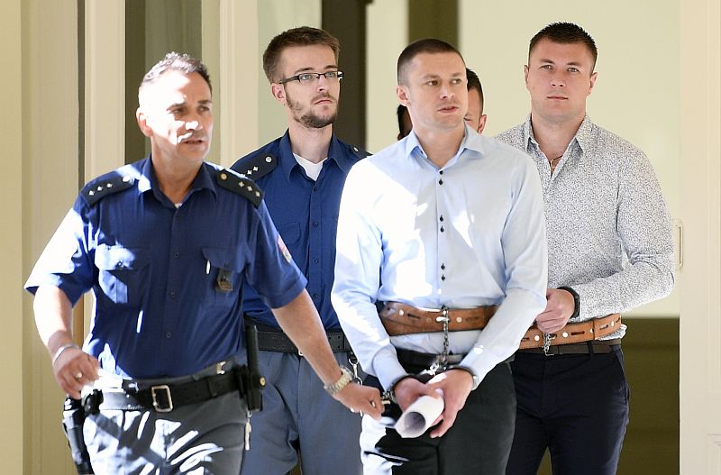 Dailonis Volkovs (v popředí) a Vladimirs Čalomovs (vpravo) v doprovodu policejní eskorty.