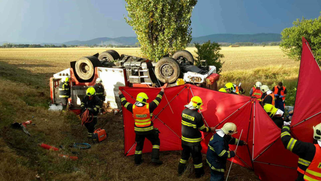 Cisterna, která byla na cestě k zásahu, po ní skončila na střeše mimo vozovku.