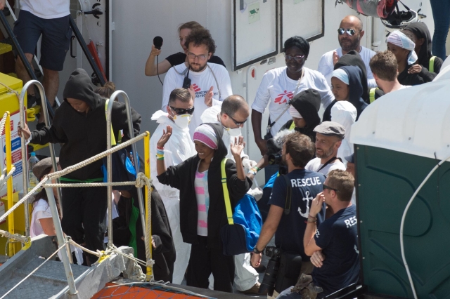 Migranti vystupují z lodi Aquarius. Migranti vystupují z lodi Aquarius.
