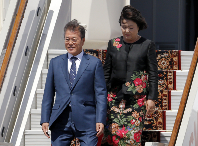 Mun Če-in vystupuje z letadla se svou manželkou Kim Čung-suk. 