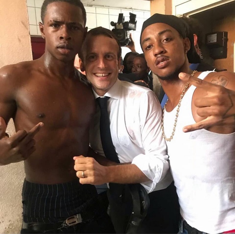 Francouzský prezident Emmanuel Macron se dvěma mladíky.