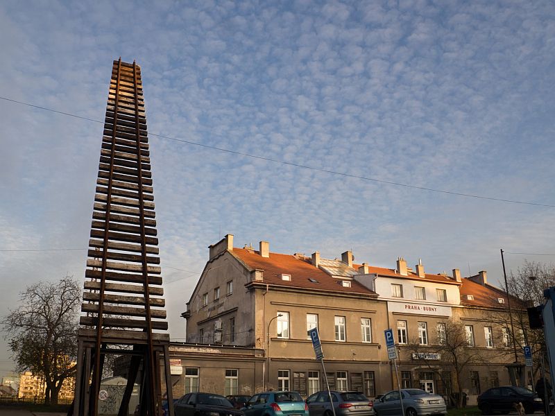 Monumentální památník v podobě kolejí vedoucích k obloze - Brána nenávratna, od sochaře Aleše Veselého před nádražím Praha Bubny.