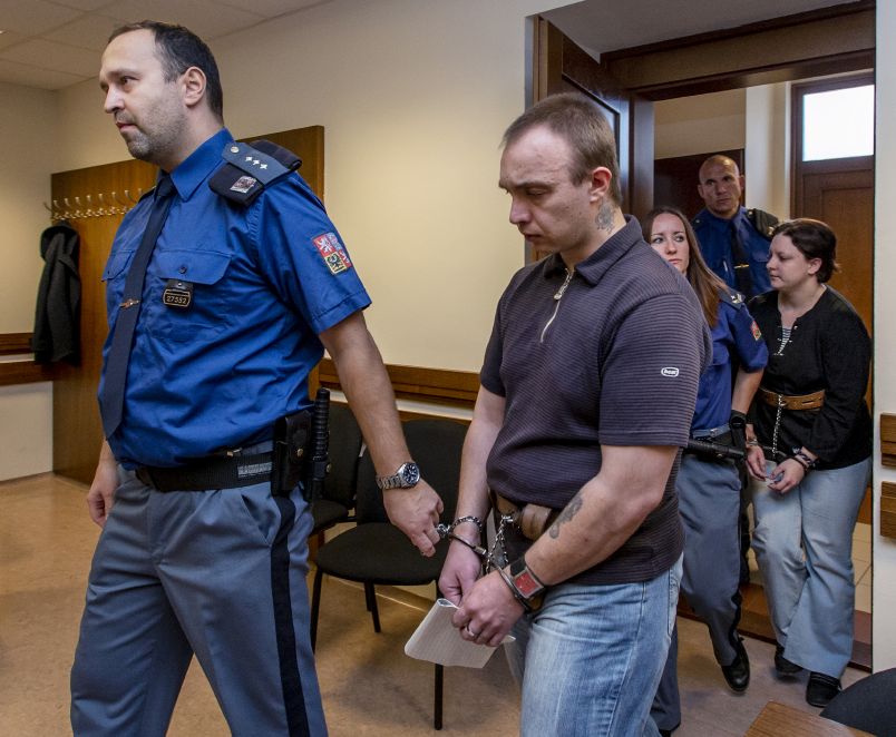 Eskorta přivádí k soudu manžele Jaroslava Janáka (druhý zleva) a Petru Janákovou (vpravo). 