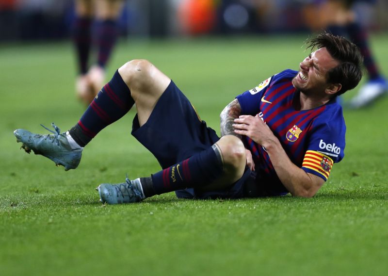 Lionel Messi trpící na zemi se zlomenou rukou.