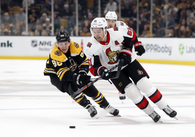 Bostonský David Pastrňák nahání Marka Stonea z Ottawy.