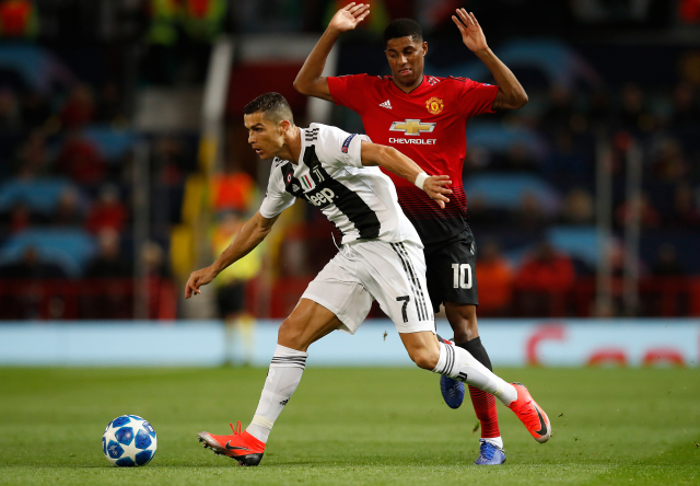Cristiano Ronaldo (v černobílém) dělá kličku Marcusi Rashfordovi.