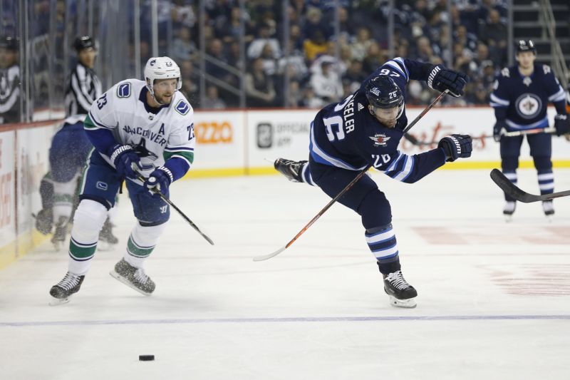 Alexander Edler (vlevo) se zranil v nedělním zápase NHL, odneslo to koleno. 