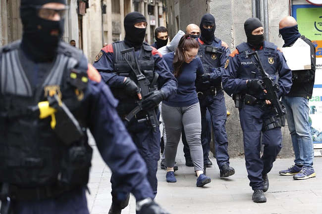Policisté vyváděli lidi z budov a nakládali je do policejních dodávek.