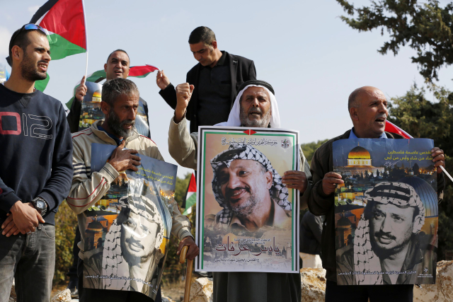Palestinci drží fotografie Jásira Arafata při výročí 14 let od jeho úmrtí. 