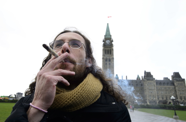 Muž kouřící marihuanu, Ottawa, Kanada.