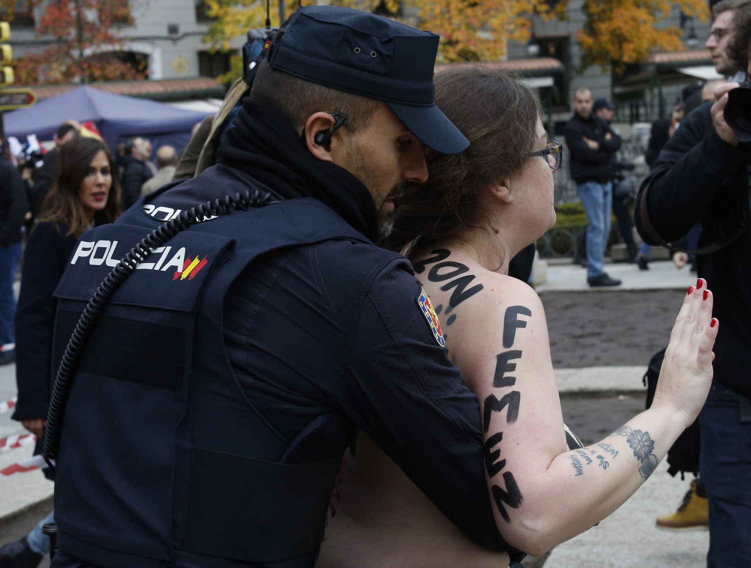 Policista zadržuje členku hnutí Femen na manifestaci v Madridu.