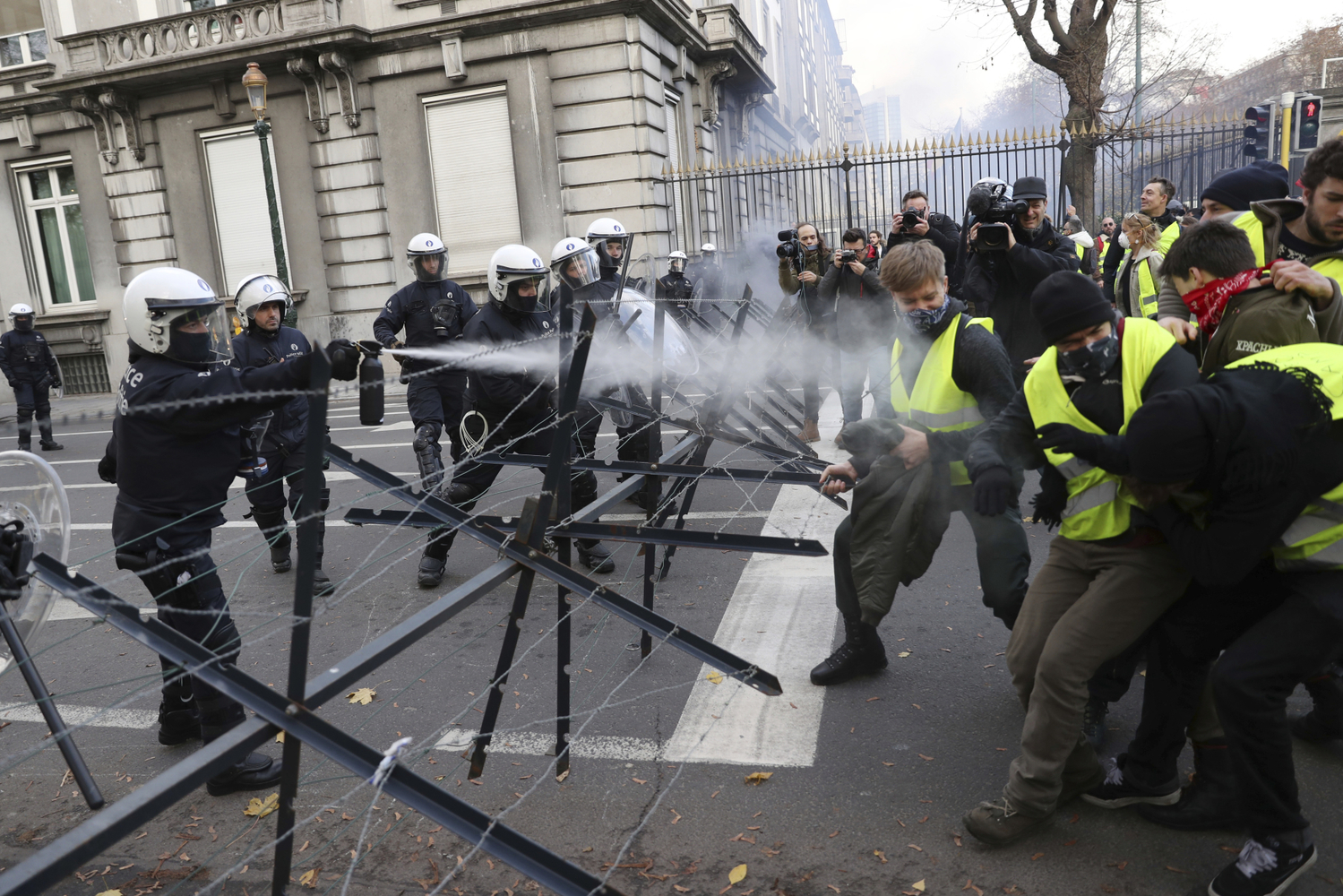 Policie stříká na demonstranty slzný plyn.