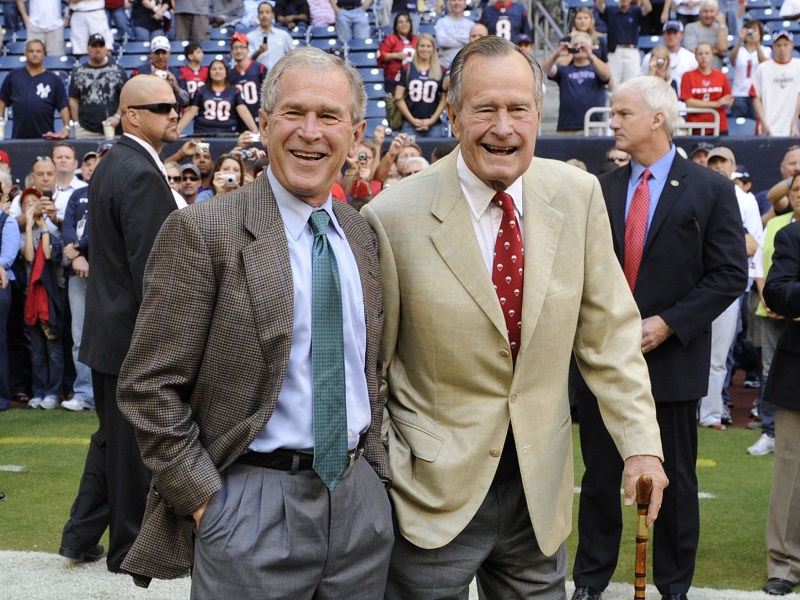 George Bush mladší (vlevo) se svým otcem na americkém fotbalu v roce 2009. George Bush mladší (vlevo) se svým otcem na americkém fotbalu v roce 2009.