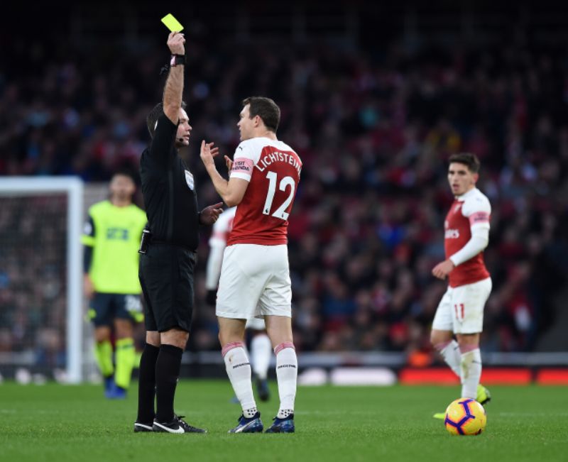 Rozhodčí Tierney uděluje žlutou kartu Lichtsteinerovi z Arsenalu. Rozhodčí Tierney uděluje žlutou kartu Lichtsteinerovi z Arsenalu.