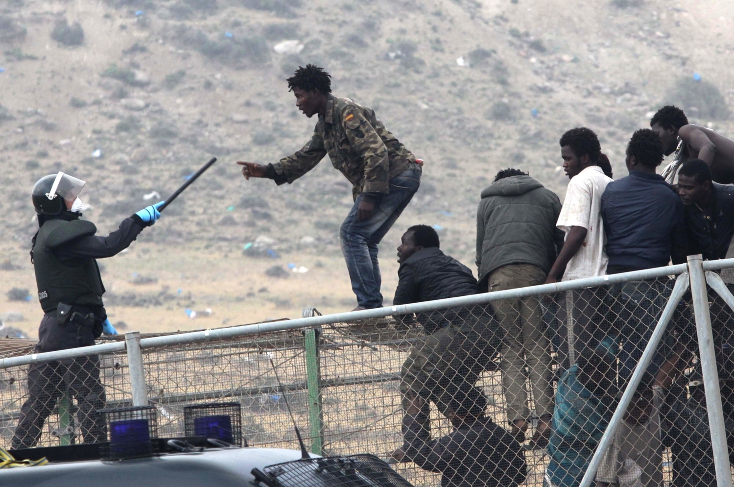 Migranti se snaží dostat přes plot oddělující Maroko od španělské enklávy Melilla.