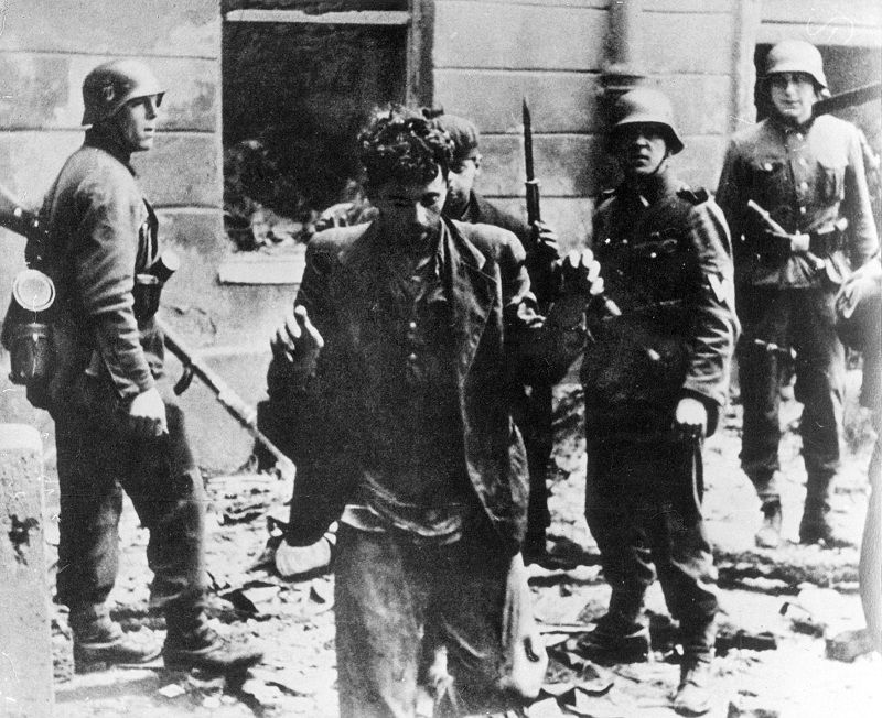 Němečtí vojáci zatýkají židovské obyvatele varšavského ghetta (1943).