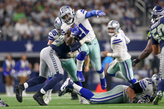 Ezekiel Elliott z Dallasu Cowboys se snaží proskočit mezi obránci.