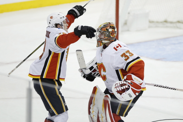 Brankář Calgary David Rittich se spoluhráčem Matthewem Tkachukem.