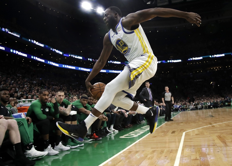 Draymond Green zachraňuje míč před vlétnutím do autu. 