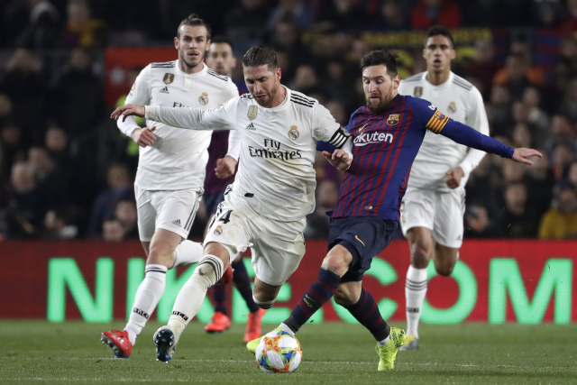 Lionel Messi (vpravo) se snaží obejít Segia Ramose z Realu. Lionel Messi (vpravo) se snaží obejít Segia Ramose z Realu.