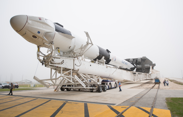 Crew Dragon na raketě Falcon 9 před zkušebním vztyčením na startovací rampu.