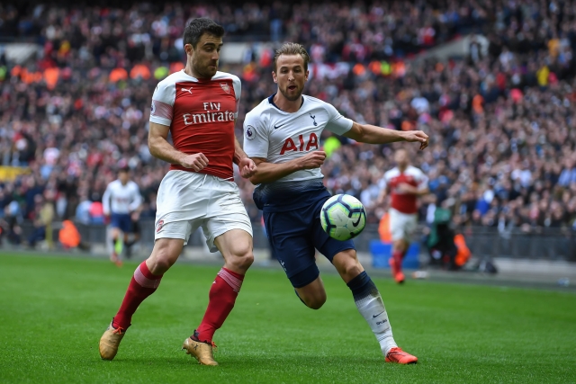 Obránce Sokratis z Arsenalu (v červeném) v souboji o míč s Harry Kanem.