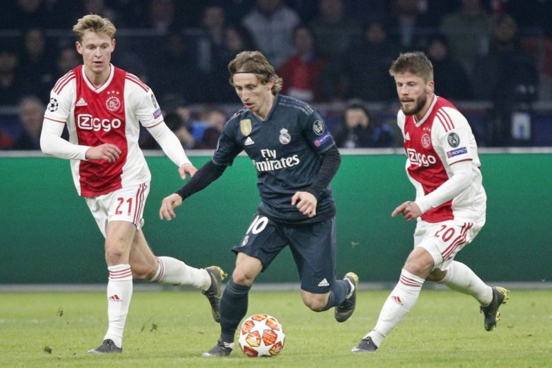 Záložník Realu Madrid Luka Modrič (uprostřed) uniká dvěma protihráčům v zápase Ligy mistrů na hřišti Ajaxu Amsterdam.