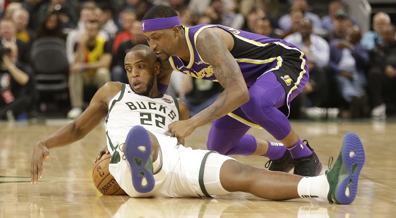 Khris Middleton (v bílém) a Kentavious Caldwell-Pope svádí souboj o míč.
