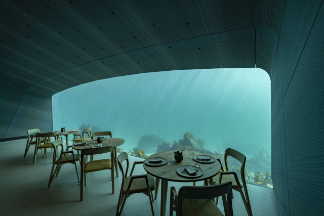 Během dne proniká do restaurace přirozené světlo filtrované zelenomodrou barvou oceánu.