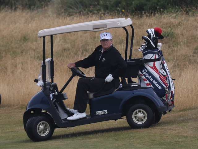 Americký prezident Donald Trump v golfovém vozidle. 