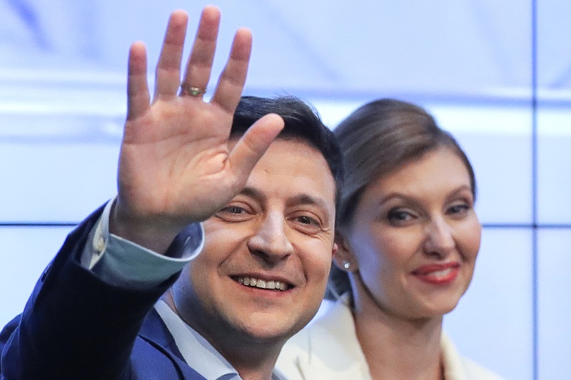 Volodymyr Zelenskyj, v pozadí s manželkou Olenou, se raduje z vítězství v prezidentských volbách.