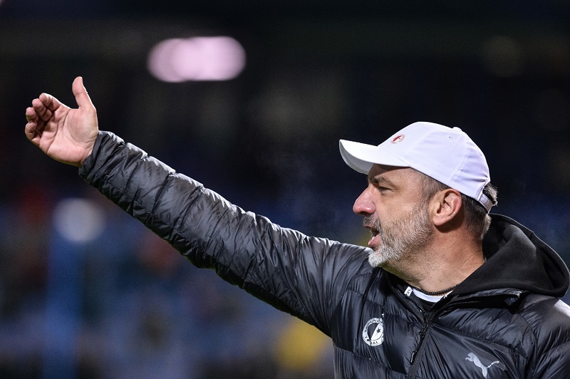 Kouč Slavie Jindřich Trpišovký na zeleném pažitu uděluje pokyny svým svěřencům.