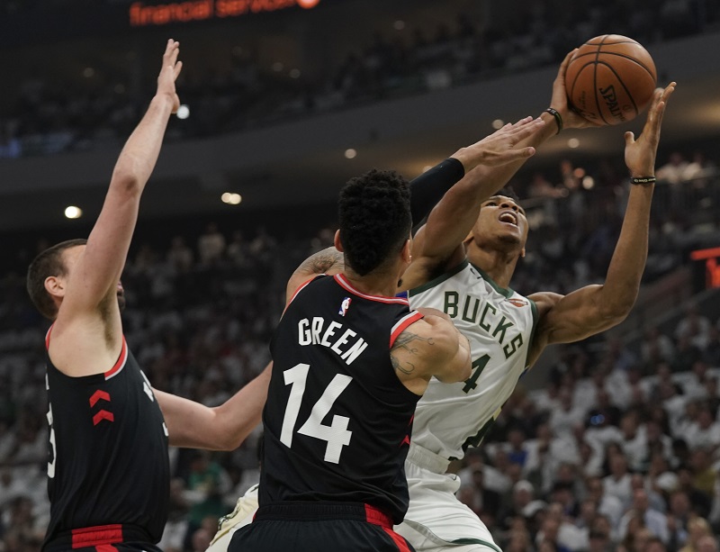 Janise Adetokunba brání dvojice Marc Gasol a Danny Green z Toronta.