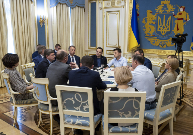 Ukrajinský prezident Volodymyr Zelenskyj (uprostřed v modré košili) při jednání v Kyjevě.
