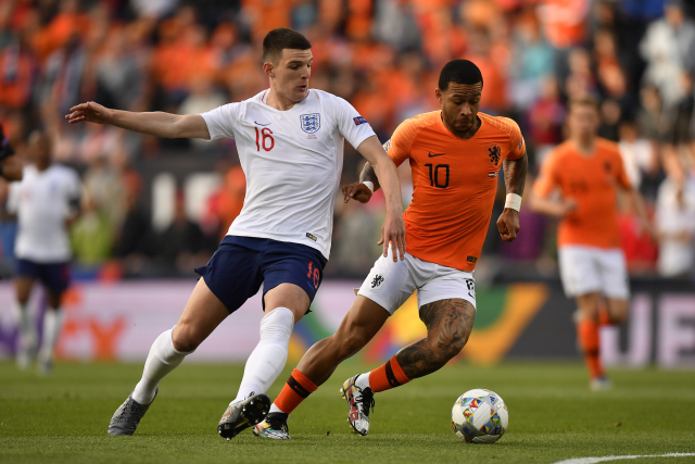 Declan Rice (vlevo) z Anglie v souboji o míč s Memphisem Depayem.