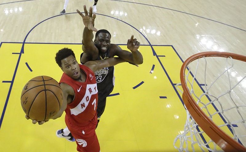 Kyle Lowry z Toronta se prosazuje přes bránícího Draymonda Greena.