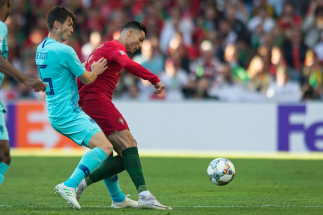 Cristiano Ronaldo (v červeném) si kryje míč před De Roonem.