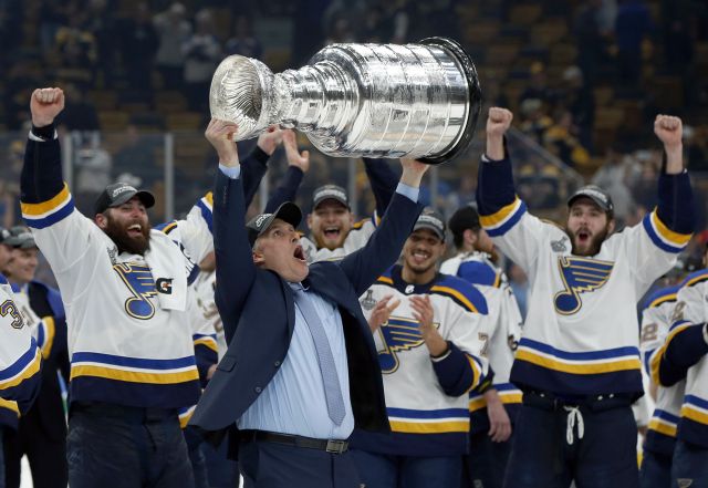 Trenér Blues Craig Berube zvedá nad hlavu Stanleyův pohár.