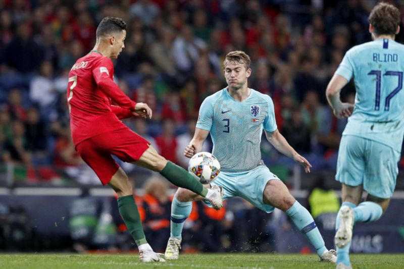 Nizozemský fotbalista Matthijs de Ligt brání Cristiana Ronalda z Portugalska.