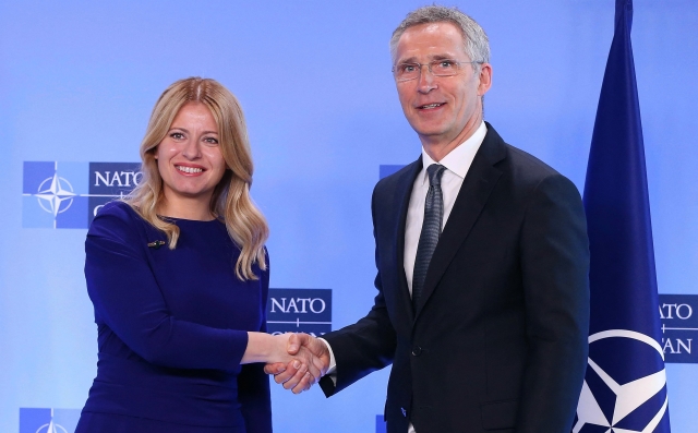 Generální tajemník NATO Jens Stoltenberg (vpravo) si potřásá rukou se Zuzanou Čaputovou.