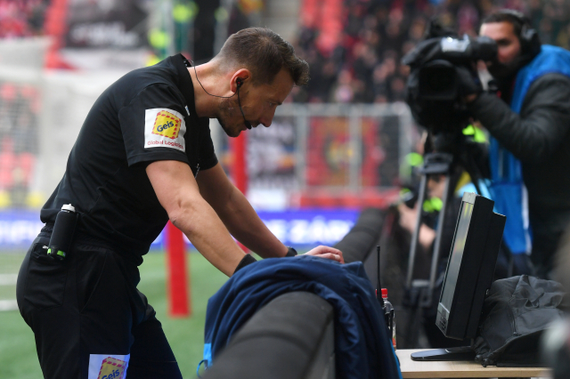 Rozhodčí Karel Hrubeš sleduje video při derby mezi Slavií a Spartou.